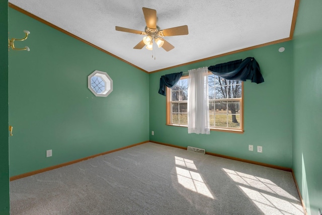 carpeted empty room with visible vents, a textured ceiling, and ornamental molding