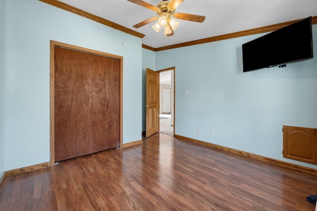 unfurnished bedroom featuring ceiling fan, wood finished floors, baseboards, and ornamental molding