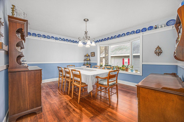 dining space with a notable chandelier, baseboards, and dark wood-type flooring