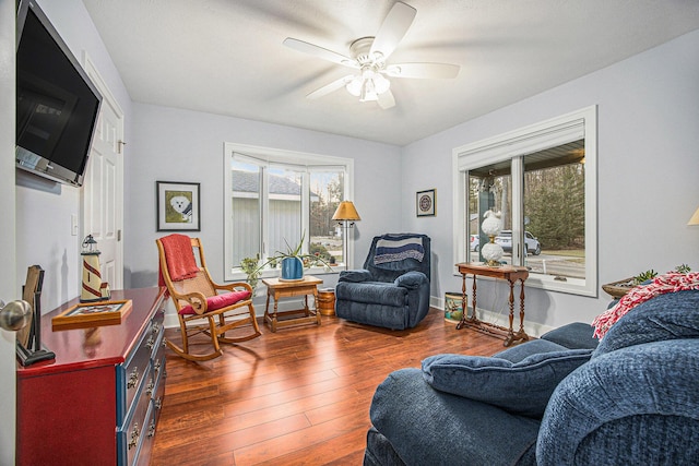 living area with hardwood / wood-style floors, baseboards, and ceiling fan