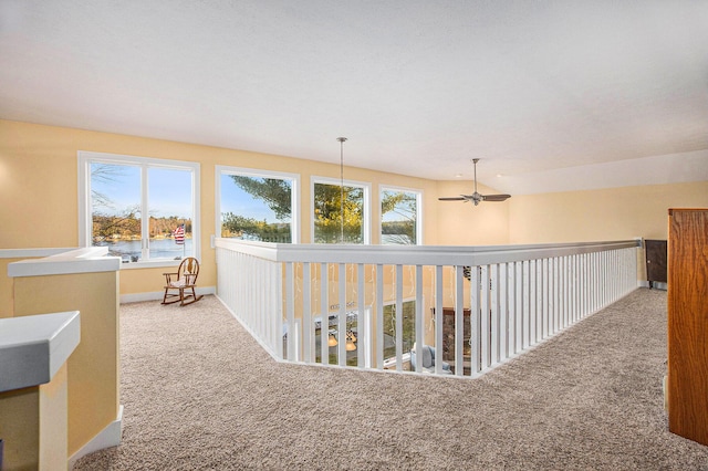 hall featuring carpet flooring and baseboards