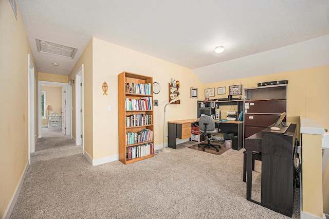 carpeted office space featuring lofted ceiling, baseboards, and visible vents