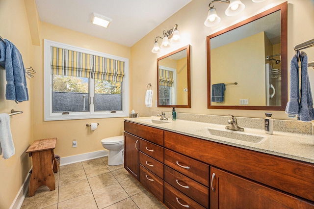 full bath with tile patterned floors, double vanity, toilet, and a sink