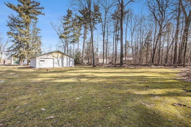 view of yard featuring a detached garage and an outdoor structure