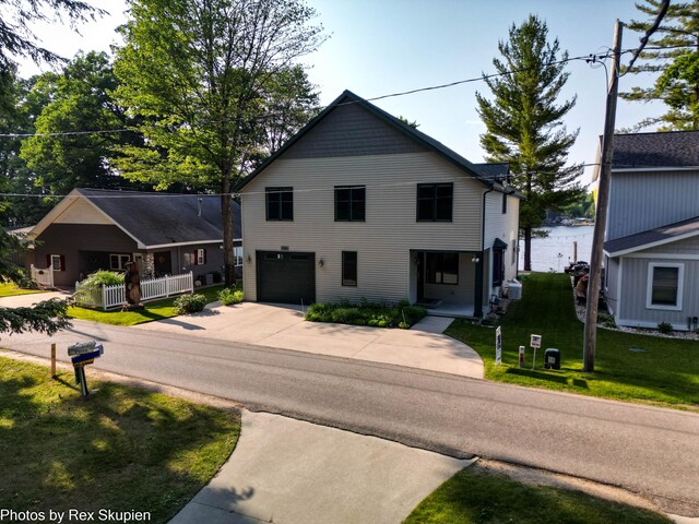 5569 Front St, Newaygo, MI 49337 - view of front of property with driveway, a garage, and a front lawn