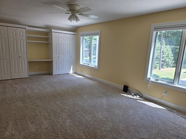 5569 Front St, Newaygo, MI 49337 - unfurnished bedroom with multiple closets, carpet flooring, and a ceiling fan