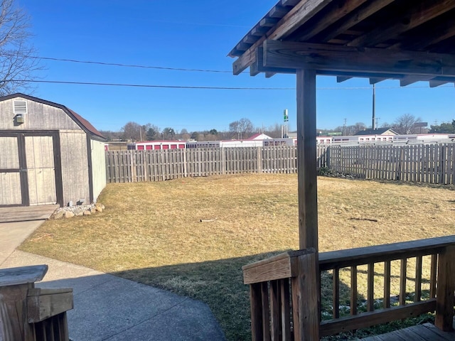 view of yard with an outbuilding, a storage shed, and a fenced backyard