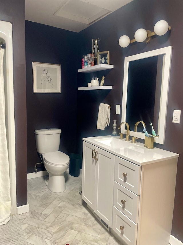 bathroom featuring vanity, toilet, baseboards, and marble finish floor