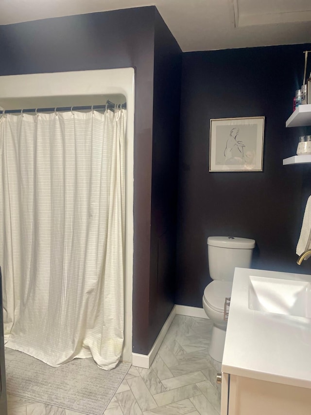 bathroom featuring toilet, marble finish floor, a shower with shower curtain, baseboards, and vanity