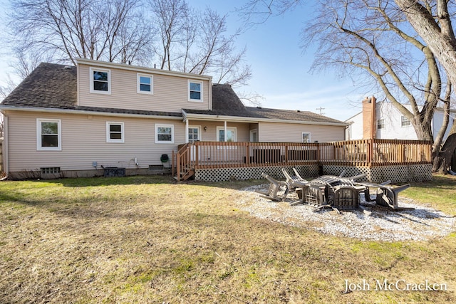 rear view of house featuring a yard, roof with shingles, and a wooden deck