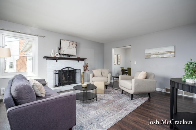 living area with baseboards, dark wood-style flooring, and a fireplace