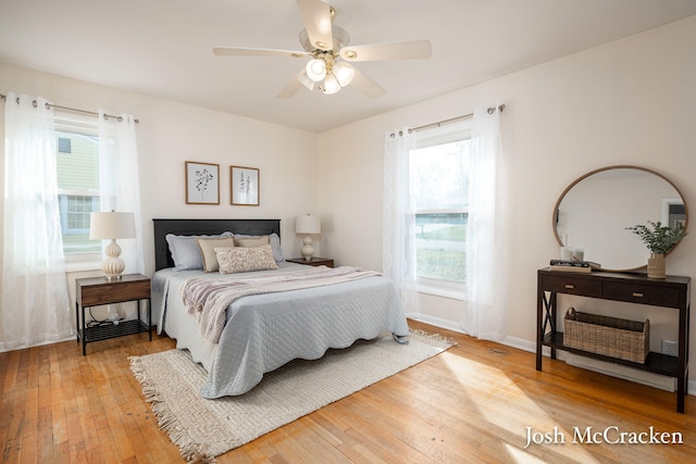 bedroom with light wood-type flooring, baseboards, and ceiling fan