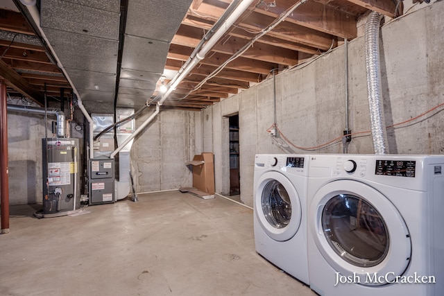 interior space with heating unit, gas water heater, and washer and clothes dryer