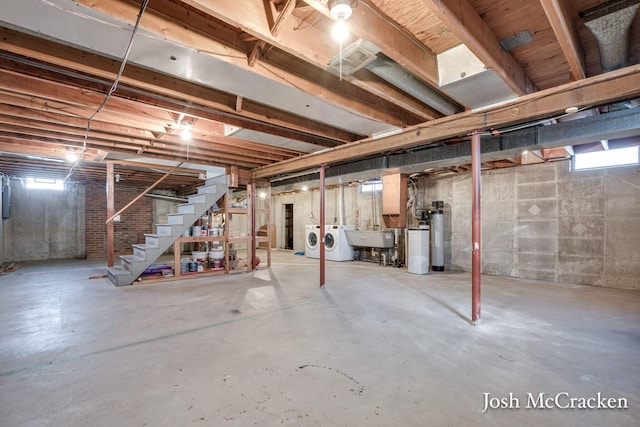 below grade area with a wealth of natural light, a sink, stairs, and separate washer and dryer