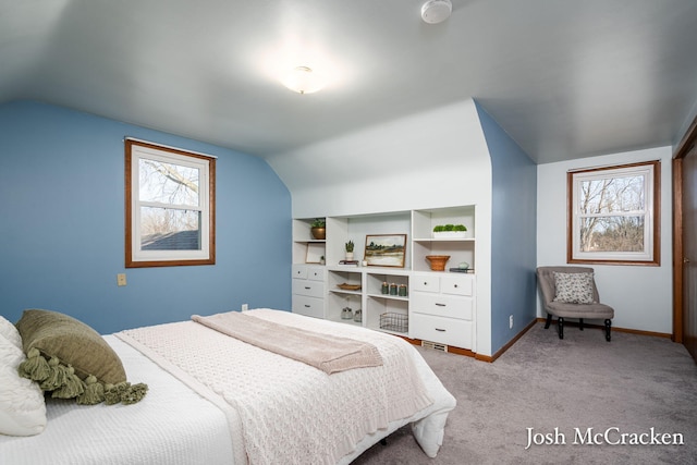 carpeted bedroom featuring baseboards and vaulted ceiling