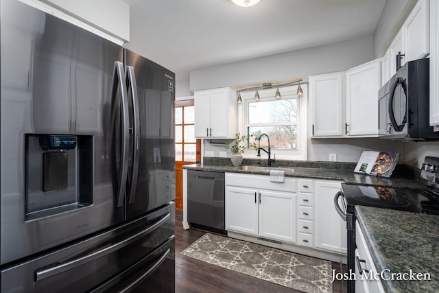 kitchen featuring black appliances, a sink, dark wood-style floors, white cabinetry, and dark stone counters