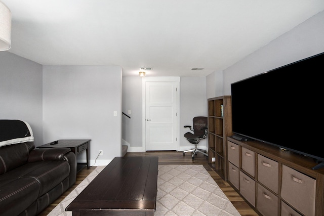 living area featuring visible vents, baseboards, and wood finished floors