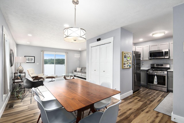 dining room with visible vents, dark wood-type flooring, a textured ceiling, recessed lighting, and baseboards