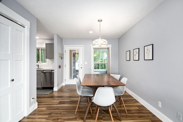 dining space featuring dark wood finished floors and baseboards