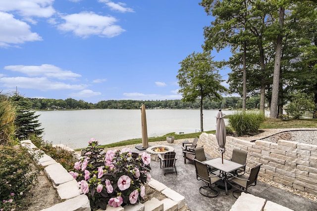 view of patio with a fire pit and a water view