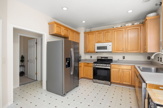 kitchen with light floors, light countertops, recessed lighting, stainless steel appliances, and a sink