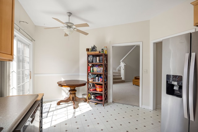 dining area featuring a ceiling fan, stairway, light floors, and baseboards