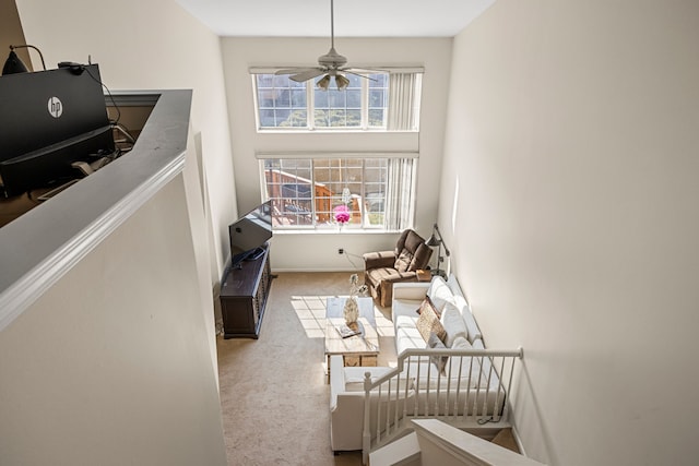 interior space featuring ceiling fan, a towering ceiling, and carpet flooring