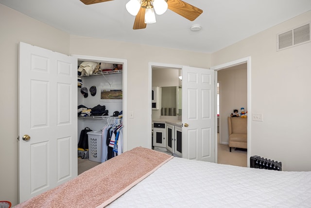 bedroom with a closet, visible vents, radiator heating unit, and a ceiling fan