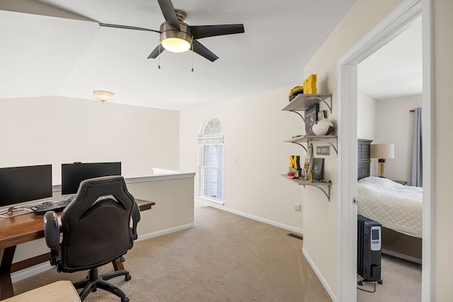 office space with visible vents, baseboards, ceiling fan, vaulted ceiling, and light colored carpet