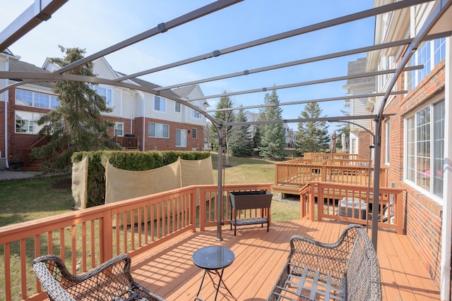 deck with a pergola and a yard