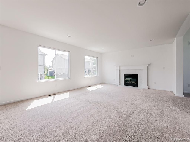 unfurnished living room featuring visible vents, baseboards, carpet, and a fireplace