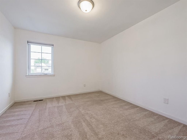 empty room featuring visible vents, baseboards, and carpet