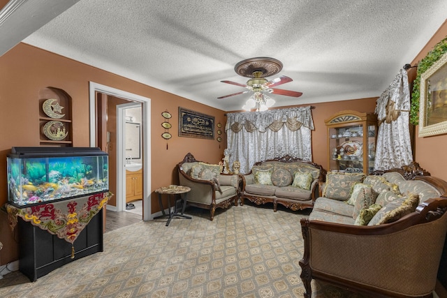 living room featuring baseboards, a textured ceiling, and a ceiling fan