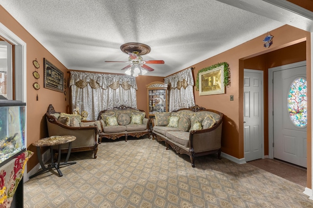 living area with baseboards, a healthy amount of sunlight, a textured ceiling, and ceiling fan