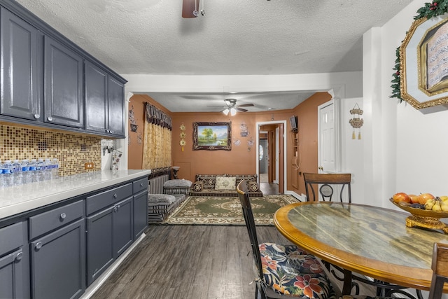 dining area featuring dark wood finished floors, radiator, a ceiling fan, and a textured ceiling