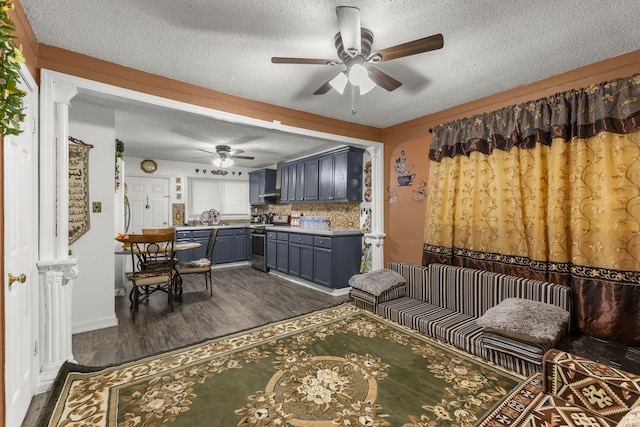 living area with dark wood-type flooring, a ceiling fan, and a textured ceiling