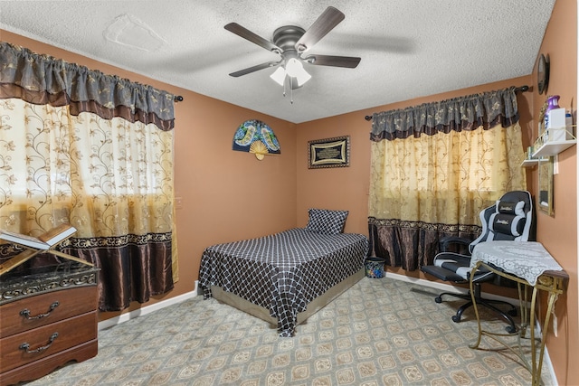 bedroom featuring baseboards, a textured ceiling, and ceiling fan