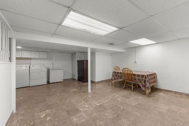 finished below grade area with fridge, baseboards, independent washer and dryer, and a drop ceiling