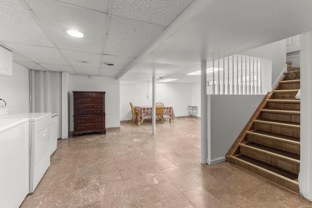 finished below grade area with washing machine and clothes dryer, stairway, a paneled ceiling, and baseboards