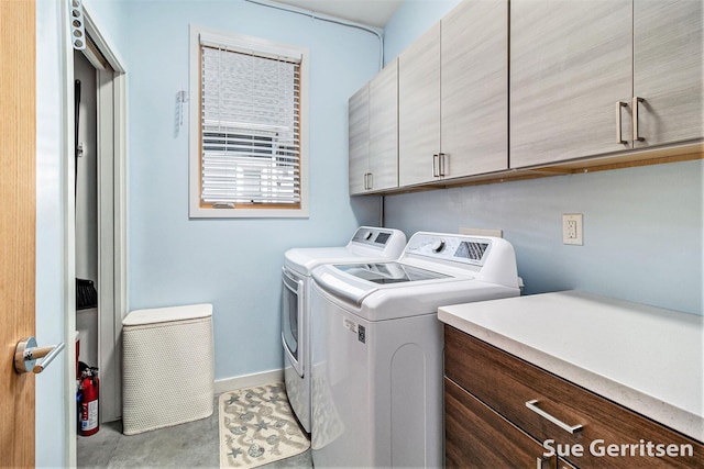 clothes washing area with cabinet space, independent washer and dryer, and baseboards