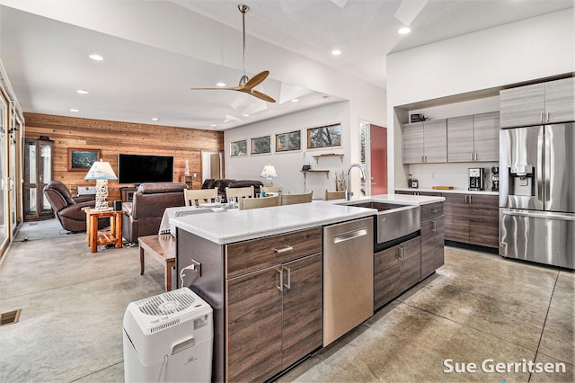 kitchen with wooden walls, concrete floors, recessed lighting, appliances with stainless steel finishes, and modern cabinets