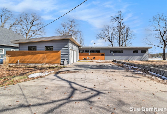 exterior space with driveway, a garage, and fence