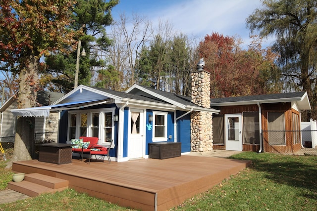 rear view of property with a lawn, a deck, fence, an outdoor hangout area, and a chimney