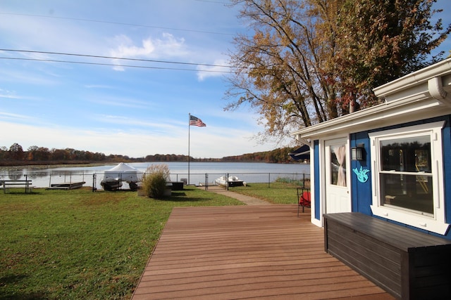 deck featuring a lawn, a water view, and fence