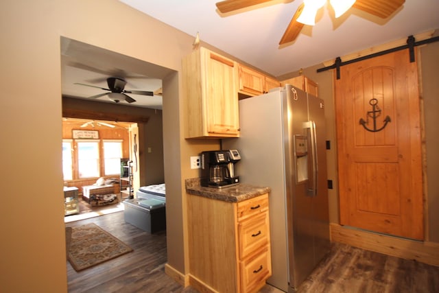 kitchen featuring a barn door, light brown cabinets, stainless steel fridge, and dark wood-style flooring