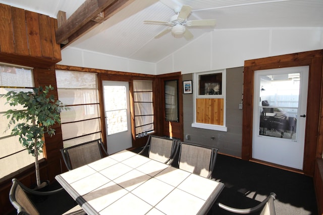 unfurnished dining area featuring a wealth of natural light, a ceiling fan, and vaulted ceiling with beams