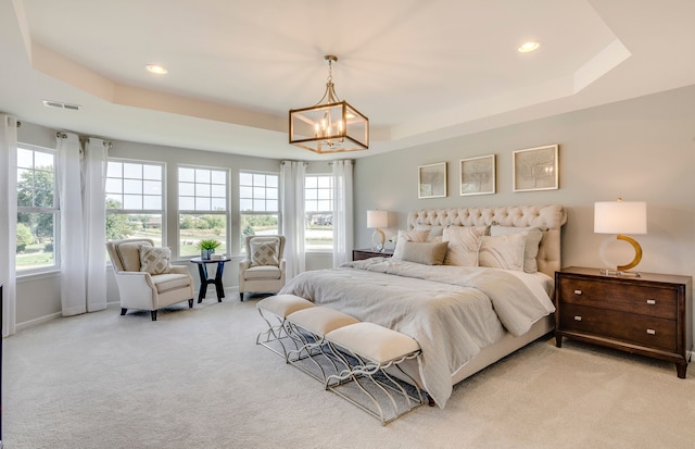 bedroom with visible vents, baseboards, an inviting chandelier, a raised ceiling, and light colored carpet