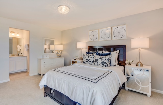 bedroom featuring baseboards, light carpet, and ensuite bath