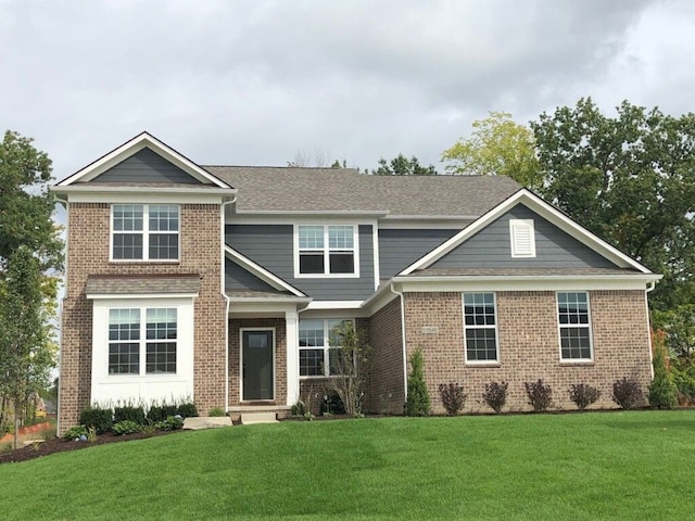 view of front of home with brick siding and a front lawn