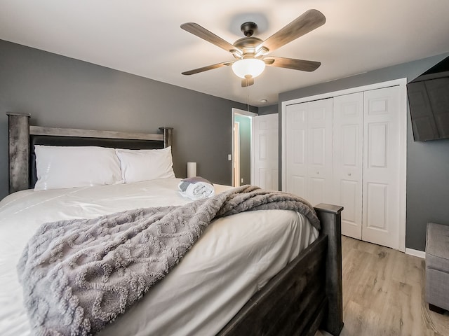 bedroom with a closet, baseboards, light wood-type flooring, and ceiling fan